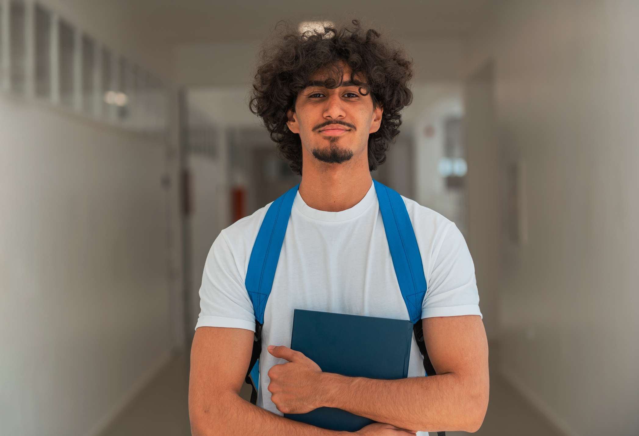 Sixth form student carrying a backpack in a school corridor.